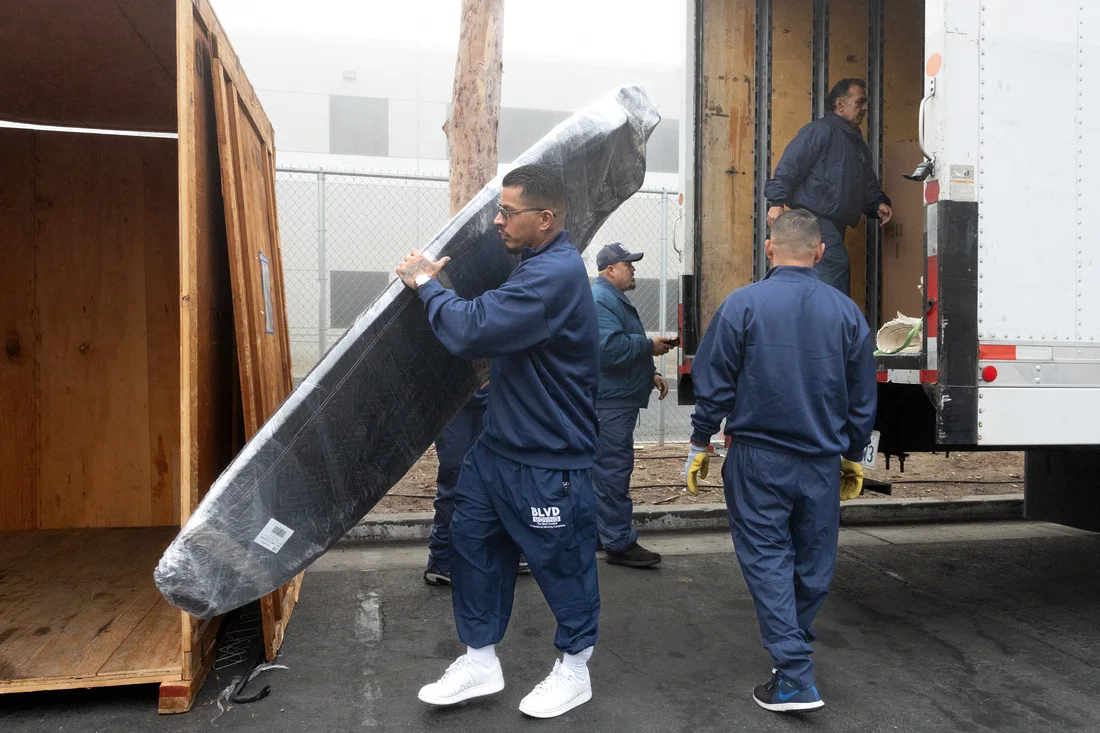 BLVD movers using specialty protection to handle a flat-screen television