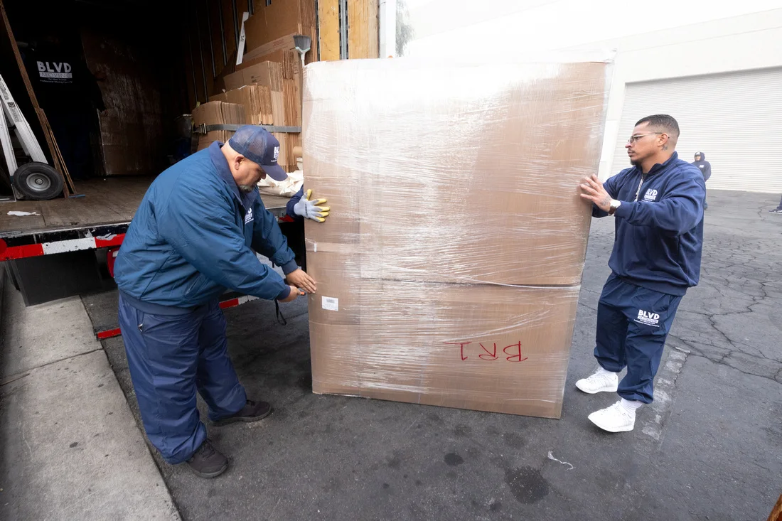 BLVD movers protecting household furniture with moving pads