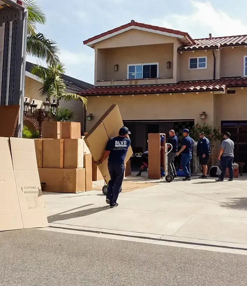 BLVD moving crew carrying packed items from a residence